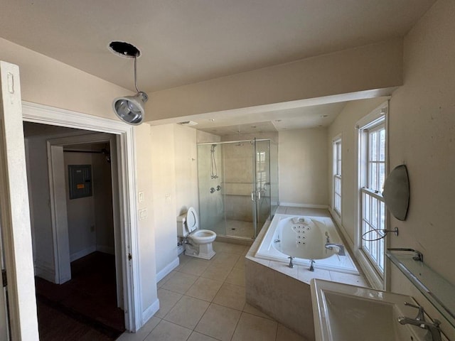 bathroom featuring tile patterned flooring, toilet, baseboards, a jetted tub, and a stall shower