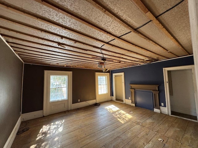 unfurnished living room featuring baseboards and wood finished floors