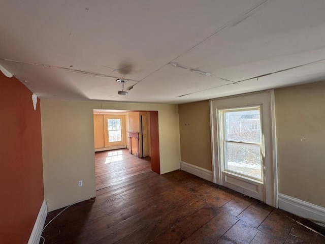 empty room featuring dark wood-type flooring and baseboards