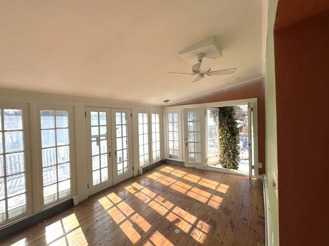 unfurnished sunroom with ceiling fan, vaulted ceiling, and french doors