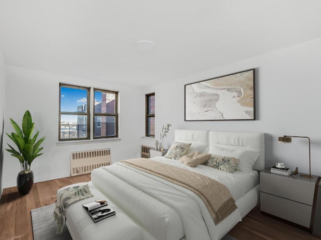 bedroom featuring radiator heating unit and dark wood finished floors