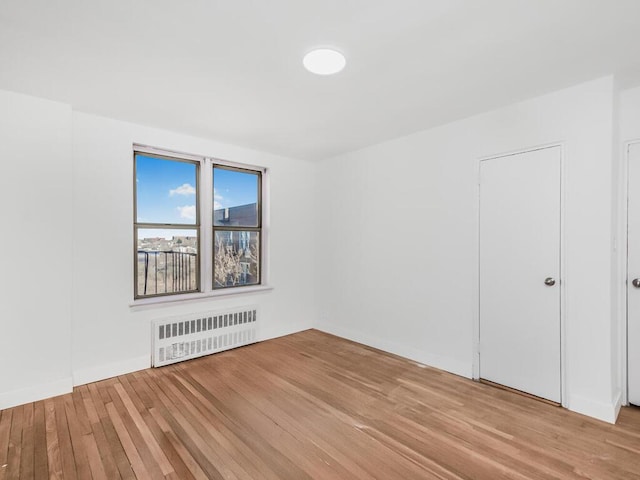 spare room with light wood-style flooring and radiator heating unit