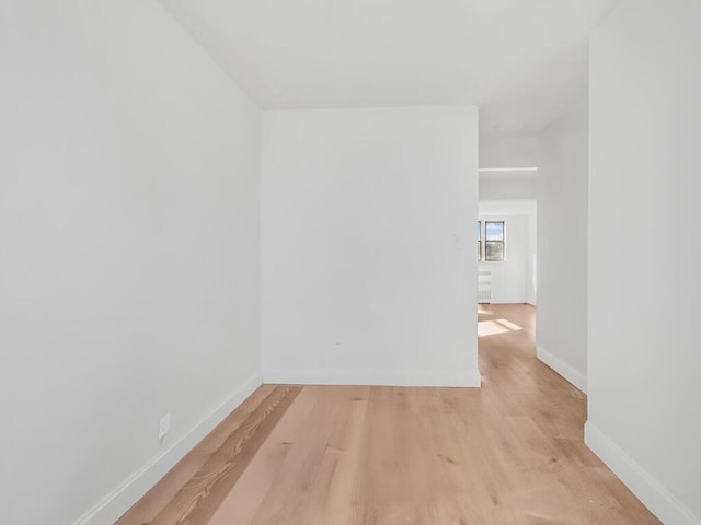 unfurnished room featuring baseboards and light wood-style floors