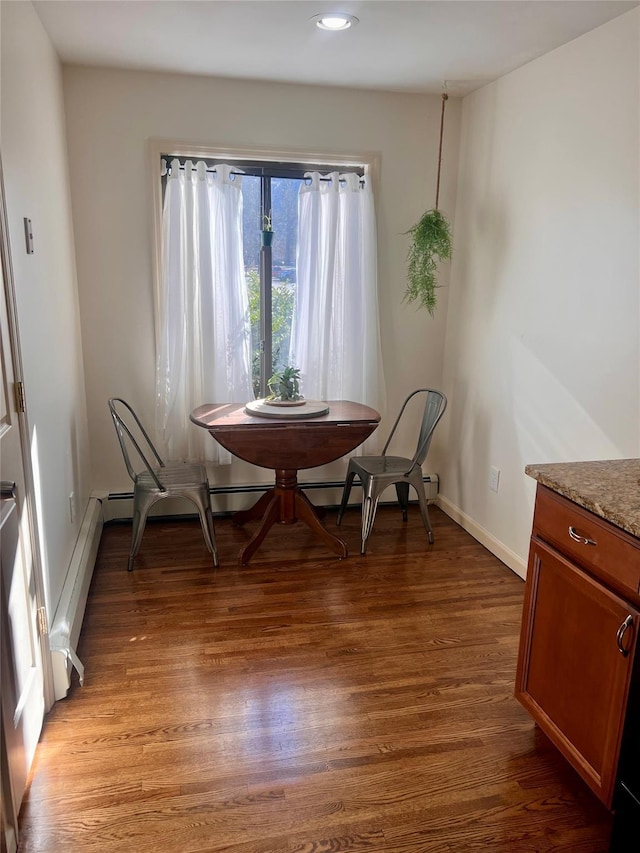 dining area with baseboards, baseboard heating, and light wood-style floors