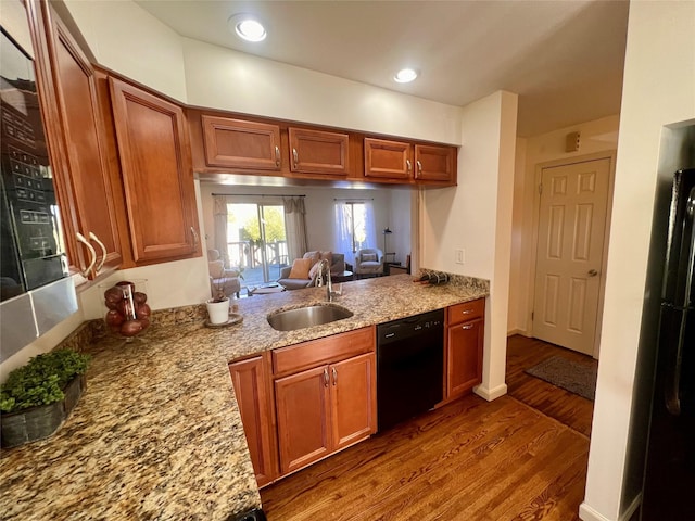 kitchen featuring dark wood finished floors, black dishwasher, brown cabinets, and a sink