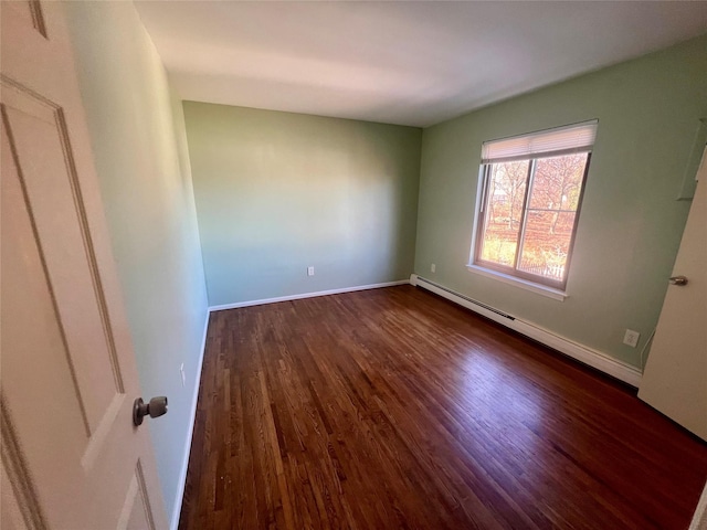 unfurnished room featuring baseboards, baseboard heating, and dark wood-style flooring