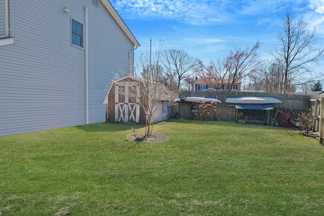 view of yard with an outbuilding, a shed, and a fenced backyard