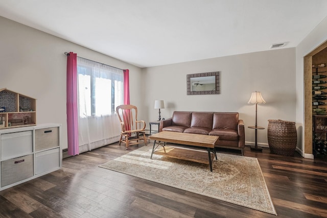 living room with dark wood-style floors, visible vents, and baseboards