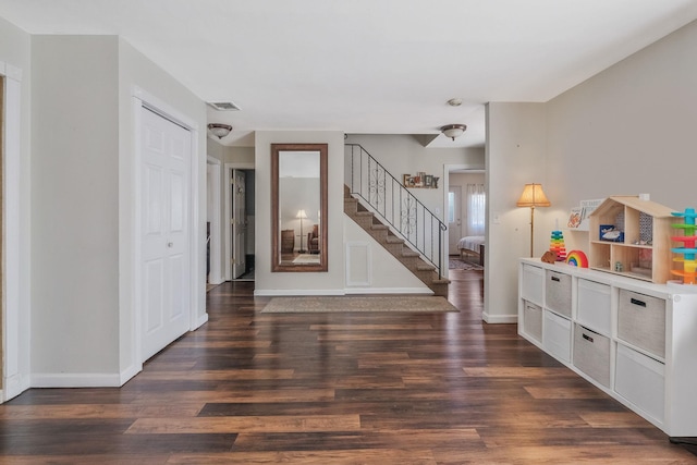 foyer featuring stairway, wood finished floors, visible vents, and baseboards