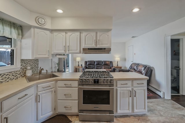 kitchen with under cabinet range hood, a sink, light countertops, high end stainless steel range, and baseboard heating