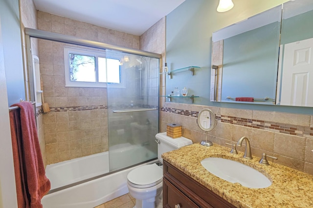 bathroom featuring tile walls, backsplash, toilet, enclosed tub / shower combo, and vanity