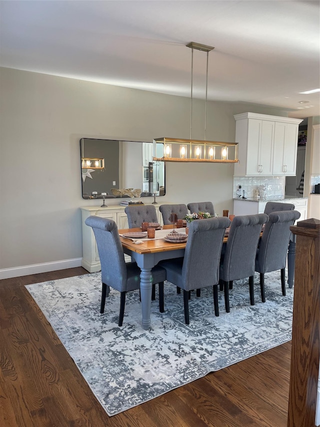 dining space with dark wood-style flooring and baseboards