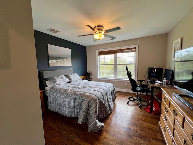 bedroom with a ceiling fan, baseboards, visible vents, and dark wood-type flooring