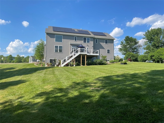 back of house with a yard, stairway, solar panels, and a wooden deck