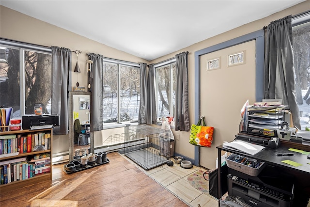 office with vaulted ceiling, baseboard heating, and wood finished floors