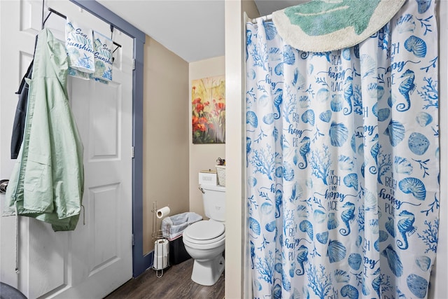 bathroom with curtained shower, toilet, and wood finished floors