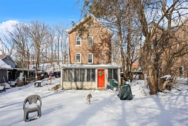 snow covered house with a sunroom