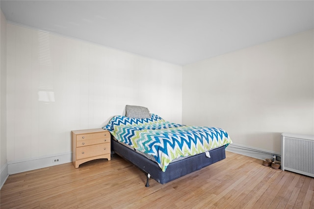 bedroom with wood-type flooring and radiator