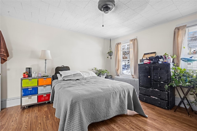 bedroom featuring radiator and wood finished floors