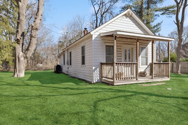 exterior space featuring a chimney, a front lawn, and a wooden deck