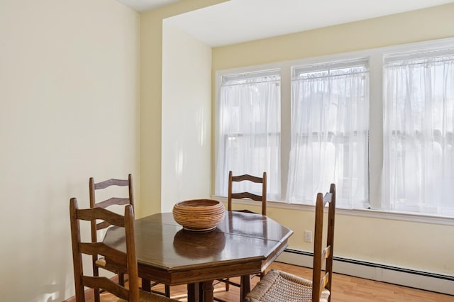 dining room featuring a baseboard radiator and light wood-style floors