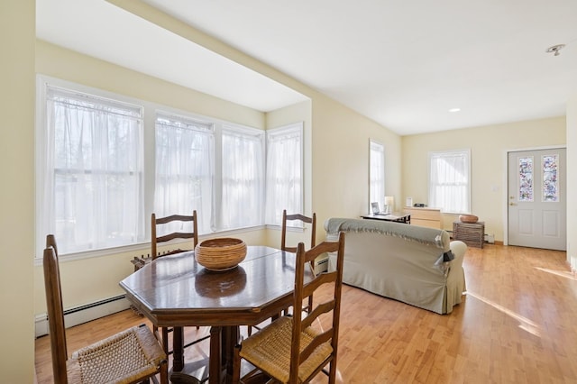 dining area featuring light wood finished floors and a baseboard radiator