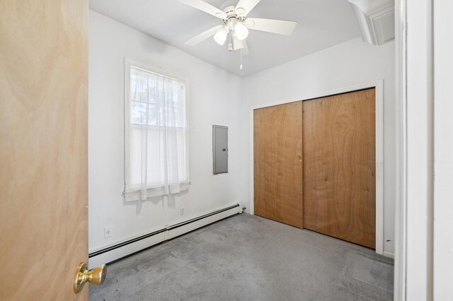 unfurnished bedroom featuring ceiling fan, baseboard heating, a closet, and electric panel