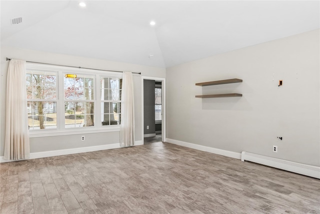 unfurnished room with lofted ceiling, a baseboard radiator, wood finished floors, and baseboards