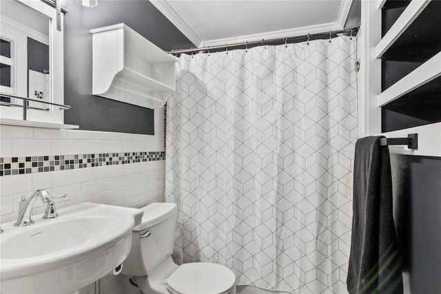 full bathroom featuring toilet, a sink, tile walls, ornamental molding, and a shower with curtain