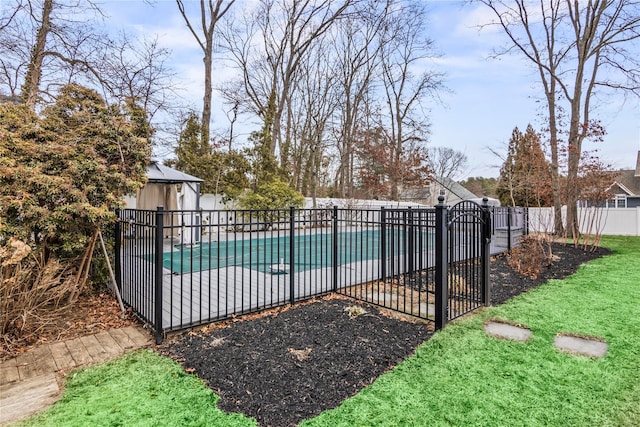 view of pool featuring a fenced in pool, a patio, a lawn, fence, and an outdoor structure