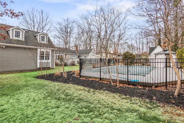 view of yard with an outbuilding, a residential view, fence, and a fenced in pool