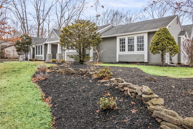 view of front of home featuring roof with shingles and a front yard