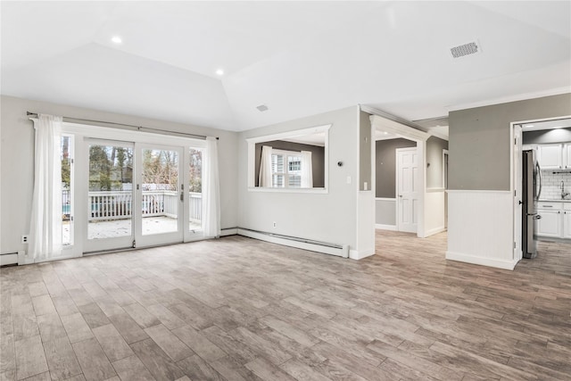 unfurnished living room featuring lofted ceiling, visible vents, baseboard heating, and wood finished floors