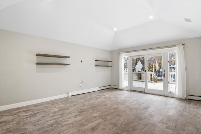 empty room with lofted ceiling, visible vents, baseboards, and wood finished floors