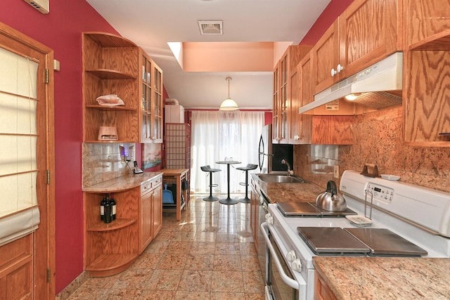 kitchen featuring white range with electric cooktop, under cabinet range hood, open shelves, brown cabinetry, and glass insert cabinets