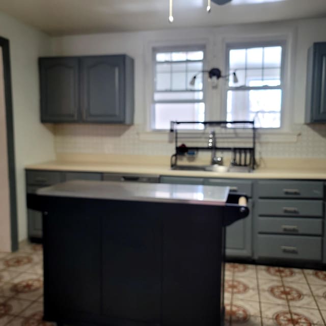 kitchen with a center island, light countertops, and gray cabinetry