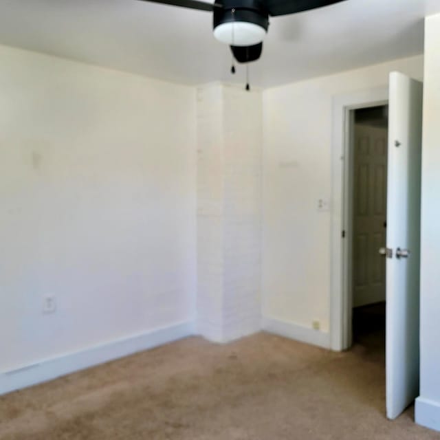 empty room featuring light carpet, ceiling fan, and baseboards