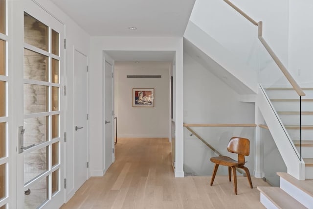 hallway with light wood-style floors and stairs