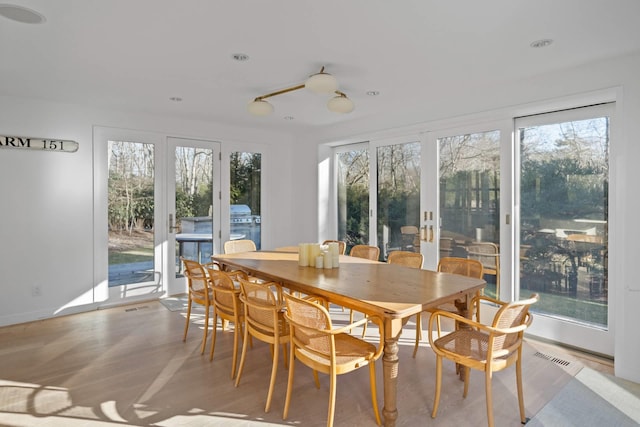 sunroom featuring visible vents, french doors, and a wealth of natural light