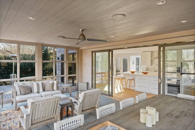 sunroom with beverage cooler, ceiling fan, plenty of natural light, and wood ceiling