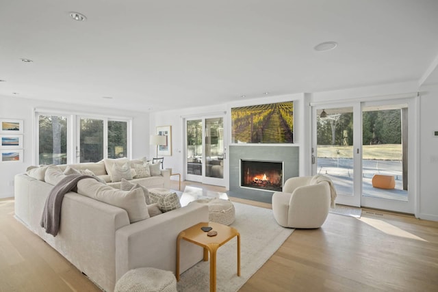 sunroom featuring a fireplace with flush hearth and a wealth of natural light