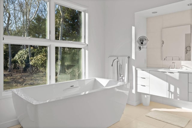 bathroom featuring a freestanding bath, vanity, and tile patterned floors