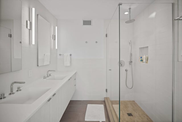 bathroom featuring a stall shower, tile patterned flooring, visible vents, and a sink