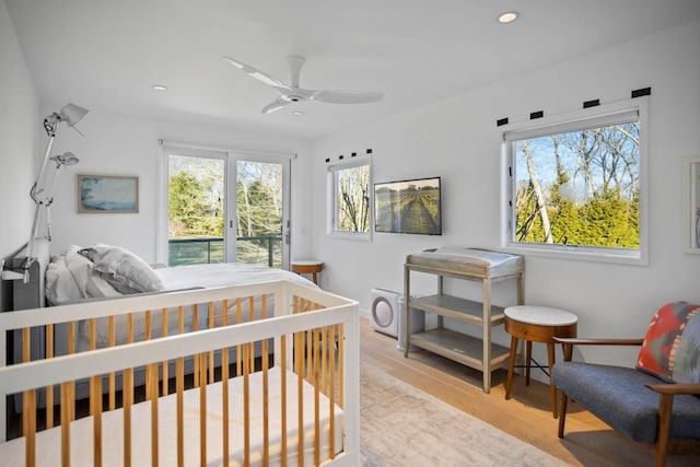 bedroom with access to outside, multiple windows, light wood-style flooring, and recessed lighting