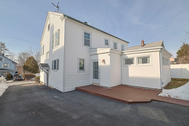 back of house featuring a wooden deck and fence