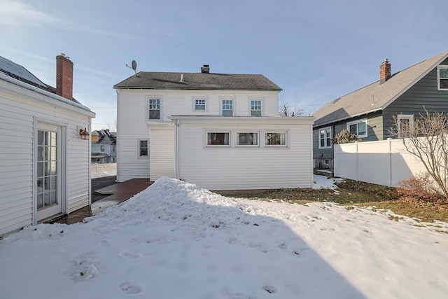 snow covered house with fence