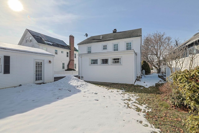 view of snow covered back of property