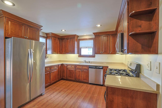 kitchen featuring light wood finished floors, appliances with stainless steel finishes, open shelves, and a sink