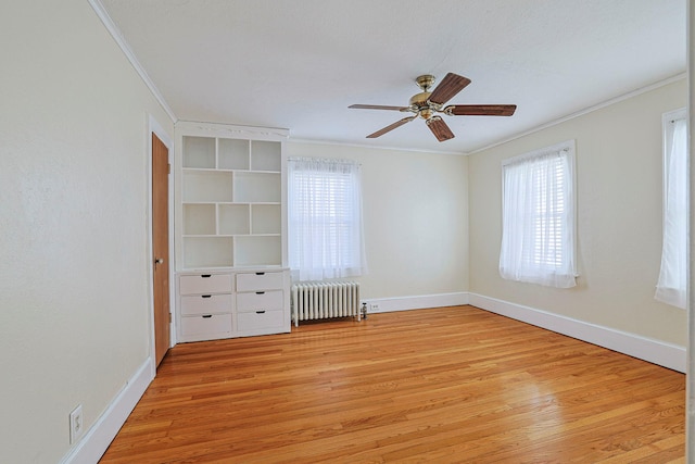 unfurnished bedroom featuring radiator heating unit, light wood-style flooring, and crown molding