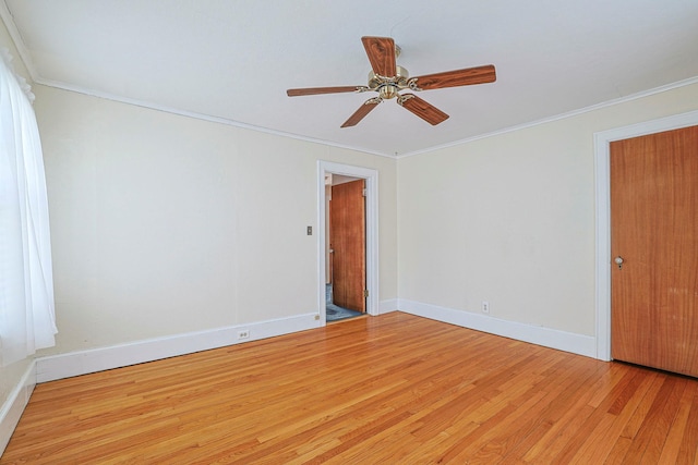 spare room with a ceiling fan, light wood-style flooring, baseboards, and crown molding